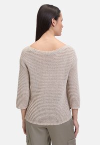 Beige gebreide trui met een brede ronde halslijn, driekwart mouwen en geribbelde structuur, van achteren weergegeven. Casual pasvorm.