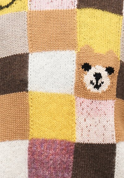 Tissu tricoté en patchwork avec des carrés jaune, marron, rose, blanc et beige, comportant un visage d'ours dans un carré beige.