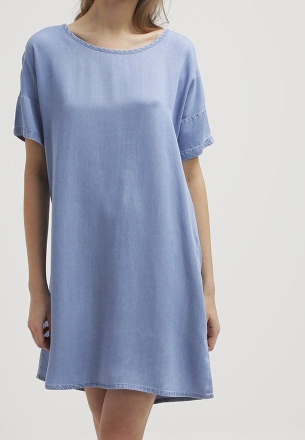 Vaaleansininen farkkuinen mekko, jossa on pyöreä pääntie, lyhyet hihat ja rento istuvuus. Mekossa on raakoja reunoja ja polvipituinen helma.