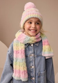 Gorro de punto multicolor con un pompón rosa y una bufanda a rayas a juego, ambos en tonos pastel de amarillo, rosa y verde, con una textura suave.