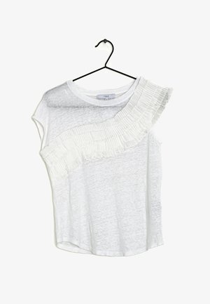 Top blanco de manga corta con un detalle de volantes plisados y texturizados a lo largo de un hombro. Hecho de una tela ligera y ligeramente translúcida. Cuelga de un gancho negro.