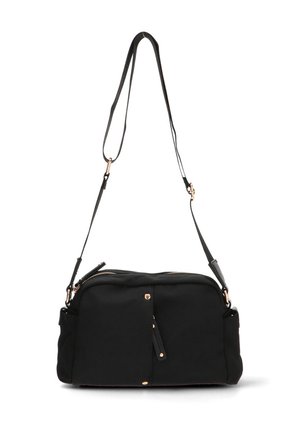 Bolso de tela negra con cierre de cremallera, correa ajustable y acentos de hardware en tono dorado. Cuenta con un bolsillo frontal con un detalle de borlas.