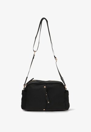 Bolso de tela negra con cierre de cremallera, correa ajustable y acentos de hardware en tono dorado. Cuenta con un bolsillo frontal con un detalle de borlas.