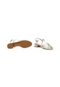 Sandalias metálicas doradas con tiras, con punta abierta, tacón de bloque pequeño y suela de goma texturizada. Presentan un intrincado diseño entrelazado.