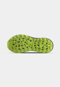 Green rubber shoe sole with jagged traction pattern, black accents, and a textured finish. Designed for stability and grip on diverse surfaces.