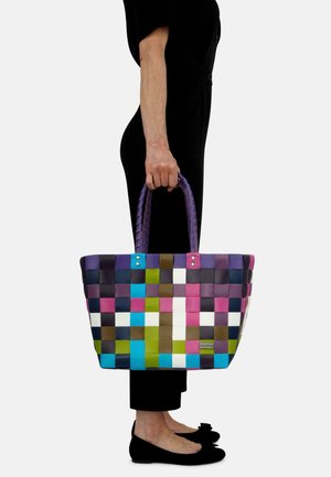 Bunte gewebte Tragetasche mit lila Griffen; verfügt über Quadrate in Grün, Blau, Pink, Weiß und dunklen Tönen; aus flexiblem Material gefertigt.