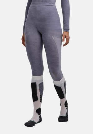 Person wearing gray seamless leggings and white, black, and gray knee-high patterned socks, standing against a white background.