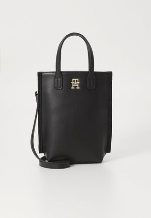 Borsa a spalla in pelle nera con doppie maniglie corte, tracolla rimovibile e logo in metallo dorato sul davanti. Texture liscia, design minimalista.