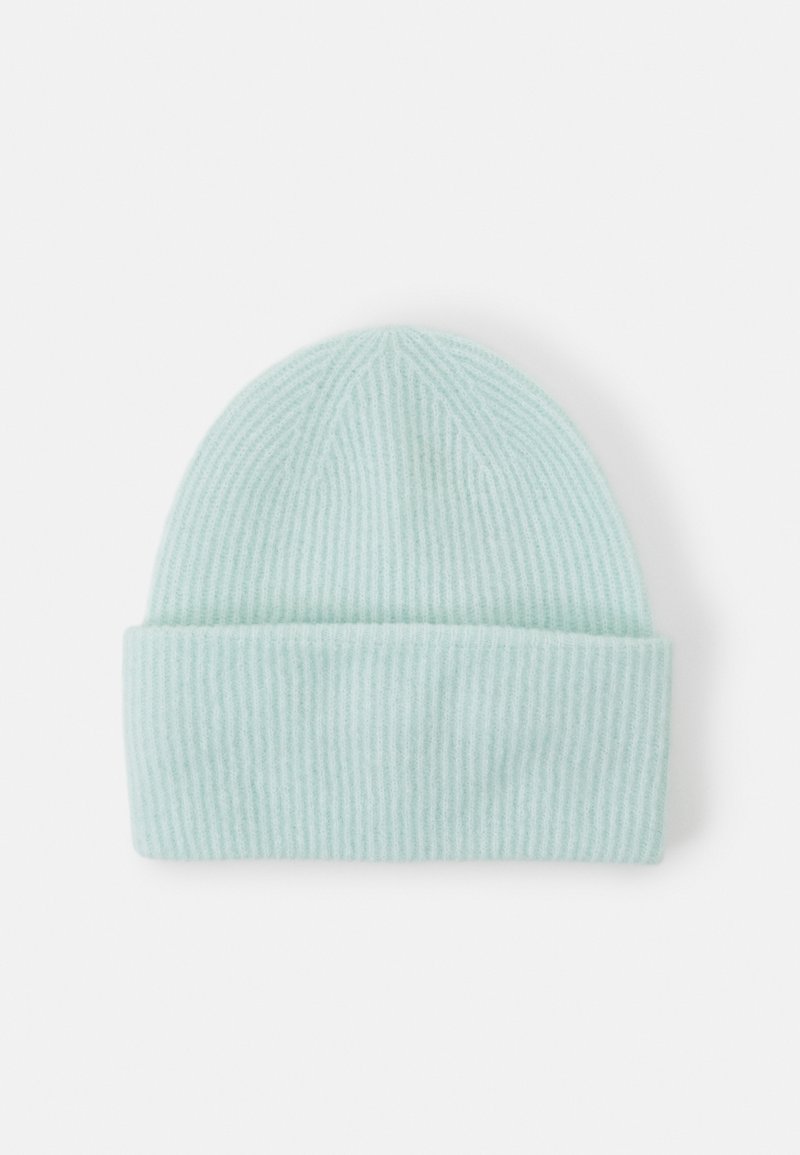 Bonnet en maille côtelée bleu clair avec revers plié, posé à plat sur fond blanc.