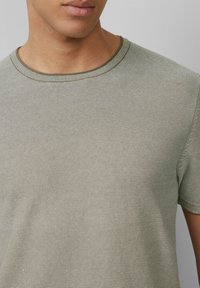 Olijfgroene gestreepte t-shirt gemaakt van zachte stof, met een ronde halslijn en korte mouwen met ribgebreide randen.