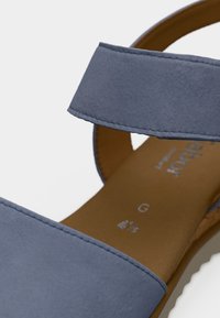 Ανοιχτό μπλε σανδάλι με φαρδιές λουρίδες, μαλακή υφή σαν σουέτ και καφέ πάτο. Διαθέτει απλή ραφή και σχέδιο που μπαίνει εύκολα.