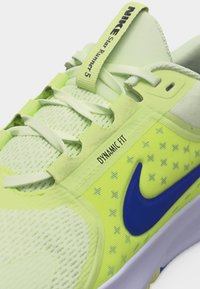 Κοντινό πλάνο ενός αθλητικού παπουτσιού Nike Star Runner 5 σε ανοιχτό πράσινο χρώμα, με λευκά κορδόνια, μπλε λογότυπο Swoosh και το κείμενο «Dynamic Fit» στην πλαϊνή πλευρά.