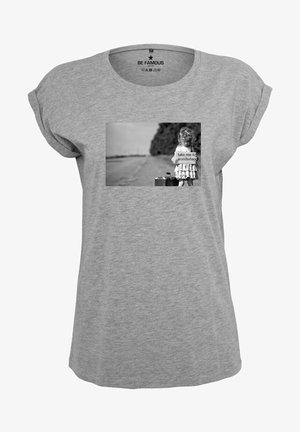 Gray short-sleeve t-shirt featuring a black-and-white photo print of a child with a suitcase and a sign that reads "take me to wonderland."