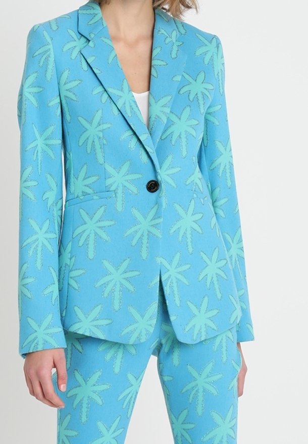 Blazer bleu avec un motif de feuilles de palmier en vert clair, fermeture à un bouton, deux poches, pantalon assorti, tissu texturé.