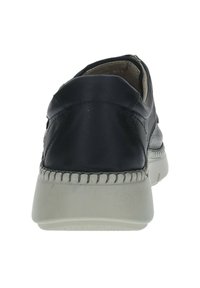 Zapato de cuero negro con parte trasera redondeada, con costuras blancas a lo largo de la suela y una suela de goma texturizada en gris. Sin patrones ni acentos visibles.