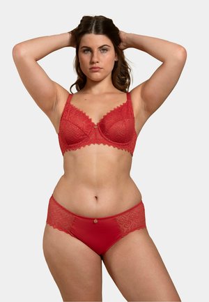 Ensemble soutien-gorge et culotte en dentelle rouge présentant des bords festonnés, un motif géométrique, et un détail en accent doré à l'avant de la culotte.