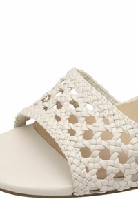 Sandale blanche à enfiler avec un dessus tissé en matériau doux, dotée d'une semelle plate lisse et d'un design ouvert.