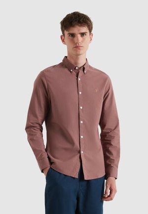 Lange mouwen, knoopsluiting shirt van mauve katoen. Heeft een borstzak met een klein, geborduurd logo. Witte knopen en een klassieke kraag.