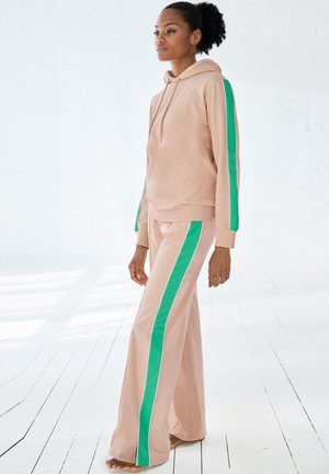 Helles rosa Hoodie- und Hose-Set mit grünen Akzentstreifen. Der Stoff wirkt glatt mit einem lässigen Schnitt und langen Ärmeln.