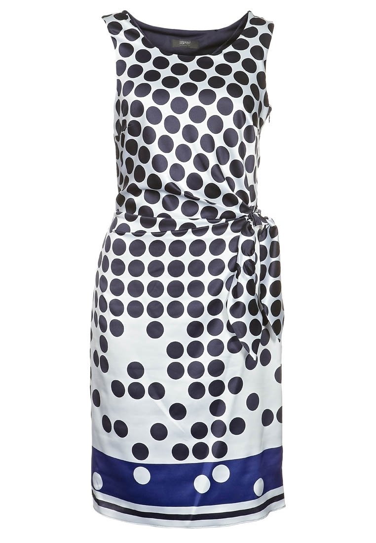 Robe sans manches en satin blanc avec de grands pois navy, une taille nouée et un ourlet navy accentué de petits pois blancs.