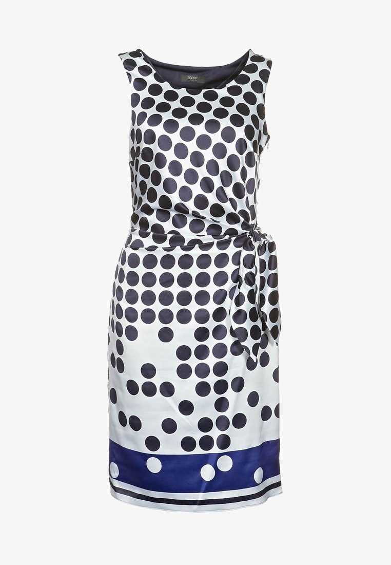 Robe sans manches en satin blanc avec de grands pois navy, une taille nouée et un ourlet navy accentué de petits pois blancs.