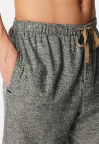 Gråmelerade sweatpants med elastisk midja och snörning, som har sidofickor och ett mjukt, texturerat tyg.