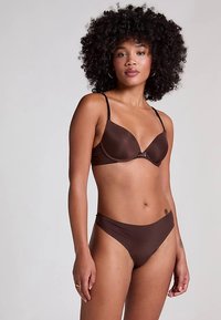 Braunes Bikini-Set mit einem glatten, gepolsterten BH mit verstellbaren Trägern und passenden Hipster-Slips, gefertigt aus weichem, elastischem Stoff.
