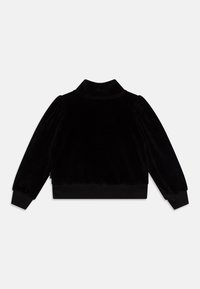 Giacca nera in velluto con colletto, maniche elastiche e fascia in vita. Tessuto liscio, chiusura con zip e maniche a palloncino.