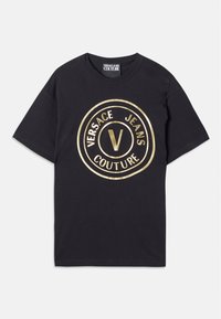 Tricou din bumbac negru cu un mare logo circular auriu pe care este scris "VERSACE JEANS" și "COUTURE." Guler rotund și mâneci scurte.