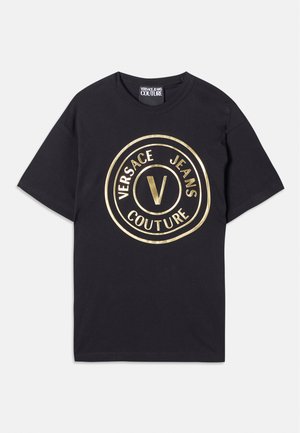 Schwarzes Baumwoll-T-Shirt mit einem großen goldenen runden Logo, das "VERSACE JEANS" und "COUTURE" zeigt. Runder Ausschnitt und kurze Ärmel.