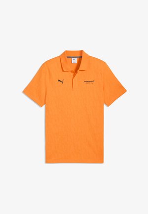 Polo orange Puma avec logo de l'équipe McLaren de Formule 1 sur le côté droit de la poitrine et logo Puma sur le côté gauche de la poitrine.