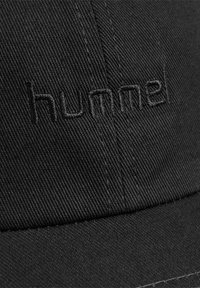Zwarte pet gemaakt van duurzaam materiaal met een gestikte "hummel" logo in bijpassend zwart garen. Het ontwerp is eenvoudig met een klassieke vorm.