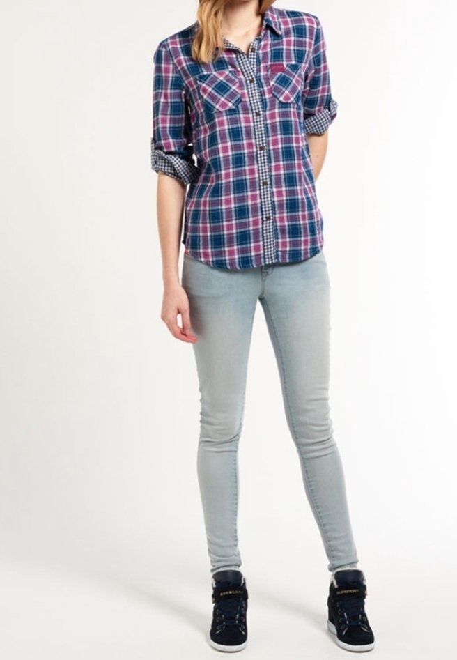 Rutigt button-up skjorta i marinblått, rosa och vitt med uppvuxna ärmar, i kombination med ljusblå skinny jeans och svarta högstövlar.