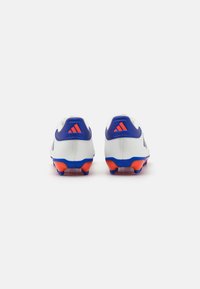 Scarpe da calcio bianche con accenti blu e arancioni, caratterizzate da una texture liscia, tacchetti conici e un design del tallone con marchio.