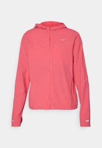 Veste légère Nike rose avec capuche, fermeture éclair complète à l'avant et accents réfléchissants sur les manches. Fabriquée en tissu lisse avec une coupe sportive.