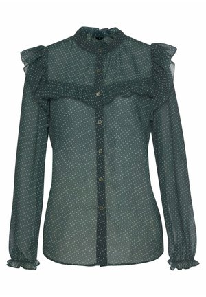 Blusa transparente de manga larga verde oscuro con lunares blancos, cuello alto con volantes, cierre de botones y detalles de volantes en el pecho y los puños.