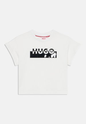 T-shirt branca de algodão com mangas curtas e decote redondo, apresentando um logótipo preto brilhante "HUGO" na frente contra um fundo sólido.