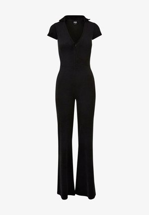 Black jumpsuit with a zip front, short sleeves, and a collar. Flared legs and a fitted waist, made of a smooth, stretchy fabric.