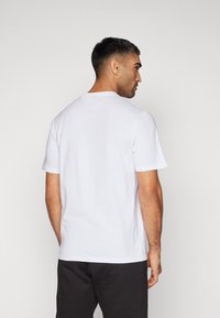 Hvid bomulds t-shirt med korte ærmer og rund halsudskæring. Stoffet har en glat tekstur og en klassisk pasform.