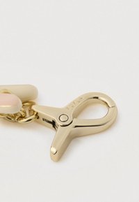 Κούμπωμα από χρυσό μέταλλο με λαμπερό φινίρισμα, προσαρτημένο σε αλυσίδα με κρεμ και ανοικτό ροζ κρίκους. "FURLA" εγχαραγμένο στο κούμπωμα.