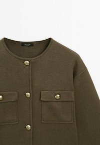 Olive green knit cardigan with round neckline, gold buttons, and two chest pockets. Smooth texture with a relaxed fit.