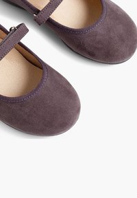 Lila Wildleder Mary Jane Schuhe mit flacher Sohle, rundem Zehenbereich und einem verstellbaren Riemen mit einer metallischen Schnalle. Weiche Innenauskleidung.