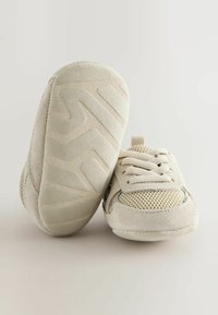 Baskets pour tout-petits beiges en daim et en mesh, avec une semelle en caoutchouc texturé au motif zigzag et des lacets pour un maintien sûr.