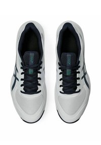 Zapatillas deportivas blancas con acentos en azul marino, materiales de malla y sintéticos, puntera redonda y cordones negros. Logo de la marca en la lengüeta y en el lateral.