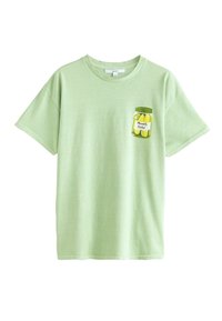 T-shirt vert clair en coton, ornée d'un graphique de pot de cornichons sur la zone gauche de la poche poitrine. Manches courtes, encolure ronde.