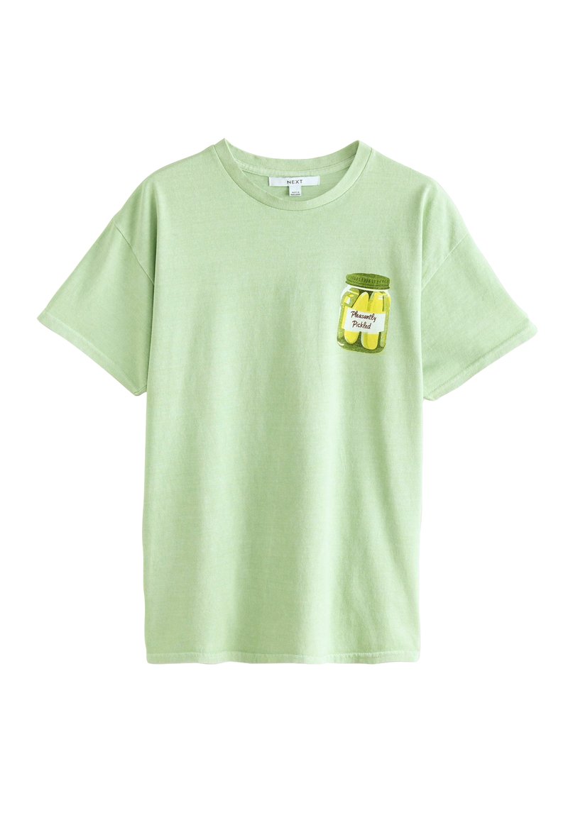 T-shirt vert clair en coton, ornée d'un graphique de pot de cornichons sur la zone gauche de la poche poitrine. Manches courtes, encolure ronde.