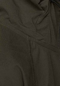 Olivgrön jacka med en jämn textur, synlig sömnad längs sömmarna och en huva med justerbara snoddar.