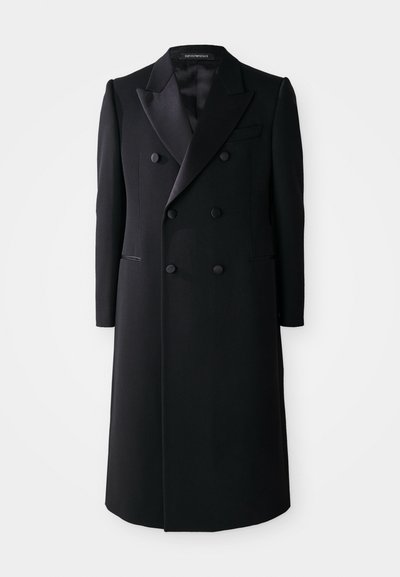 Melns divrindu mētelis ar satīna izgriezumu, divām priekšējām kabatām un tiešu piegriezumu. Izgatavots no gludas, teksturētas auduma.