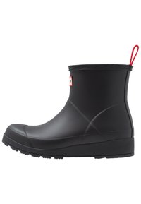 Botte de cheville en caoutchouc noir avec un bout rond, texture lisse, léger talon et onglet rouge à l'arrière ; présente un motif de semelle extérieur moulé.