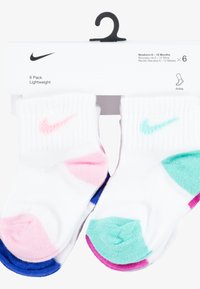 Hat pár fehér boka zokni újszülötteknek, színes részletekkel rózsaszínben, kékben és türkizben, mindegyik zoknin Nike logóval.